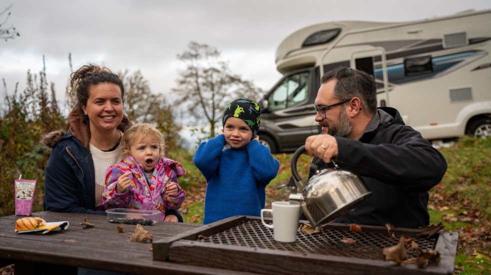 Two adults and two children eating outdoors